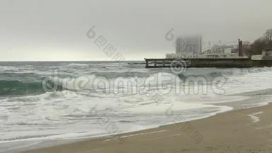 沙滩和波涛汹涌的大海，码头和高楼大厦在雾中，乌云密布